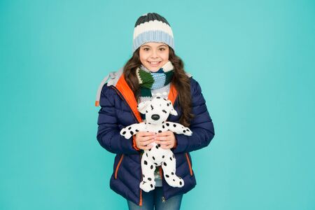 Charity concept. Pet fundraising ideas. Lovely smiling kid friendly with dog. Shelter for animals. Dalmatian dog. Happy small smiling child play with soft dog blue background. Little child play toyの写真素材