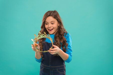 looking perfect. find your motivation. small girl in queen crown. feel herself like big boss. being egoist. reward for real champion. little princess. selfish kid long curly hair. luxury and successの写真素材