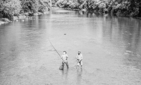one mission. Big game fishing. male friendship. father and son fishing. adventures. two happy fisherman with fishing rod and net. recreation and leisure outdoor. hobby and sport activity. Trout bait.の写真素材