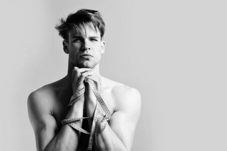 Man with naked torso and measuring tapesの写真素材