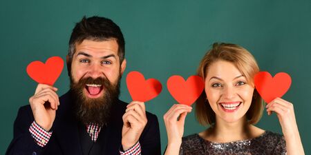 Couple in love holds hearts on green grey background.