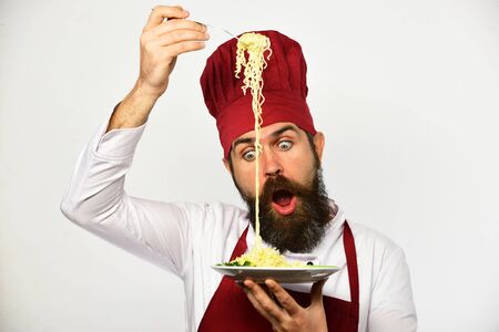 Cook with shocked face in uniform holds fork and plate.の写真素材