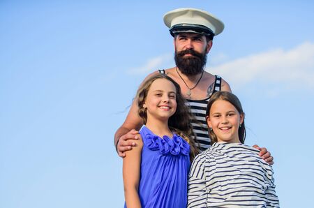 bearded sailor with kids. father back home. family day. dad and daughters outdoor. ship captain welcome on board. small girls marine fashion. parenting discipline. sea cruise. have good swimの写真素材