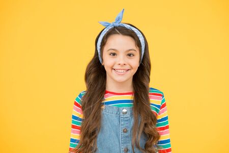 Adorable little girl with perfect curly long hair. Shampoo hair and conditioner. Hairdresser salon. Professional tips hair care. International childrens day. Irresistible joy. Cute baby headscarf bowの写真素材