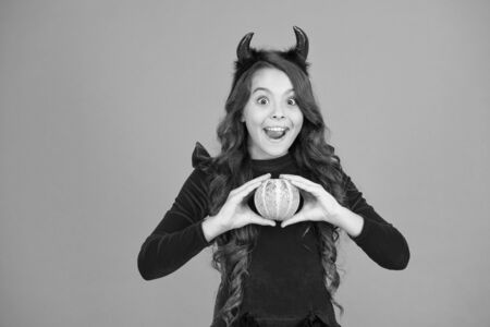 Jack lantern concept. Prepare decorations. Small child imp style accessory hold pumpkin. Halloween party. Halloween traditions. Autumn holiday. Little girl cute small horns celebrate Halloweenの写真素材