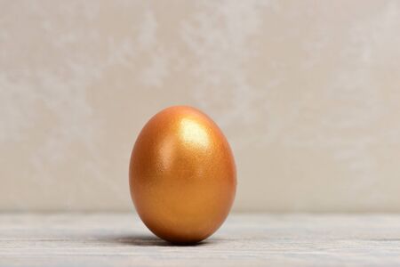traditional egg painted in golden metallic color on grey background, happy easter concept, luxury and success, birth and future life, business and finance, antique art and retirementの写真素材