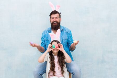 looking for eggs. happy easter holiday. small girl wear funny bunny ears with dad. family began easter egg hunt. spring holiday season. rabbit family party. happy father and daughter celebrate easterの写真素材