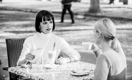 Closest people. Girls friends drink coffee talk. Conversation women cafe terrace. Friendship friendly relations. Revelation and support. Trustful communication. Friendship sisters. Friendship meetingの写真素材