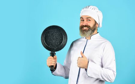 Kitchen utensils. Healthy food cooking. cooking tasty dish. bearded man hold frying pan. Cooking in pot. for preparing food. Bearded man cooking in kitchen. culinary and cuisineの写真素材