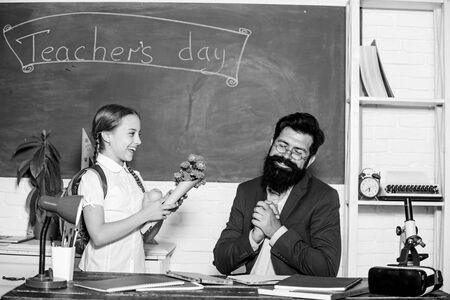 back to school. Happy teachers day. small school girl kid with flower bouquet. teachers day. Daugghter and father with flowers. knowledge day is 1 september. flower present for best teacherの写真素材