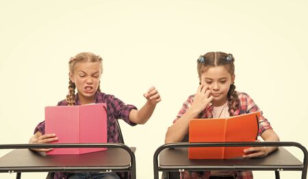 Personal attitude determines success. Acquiring knowledge. Small girls with books sit at desks...