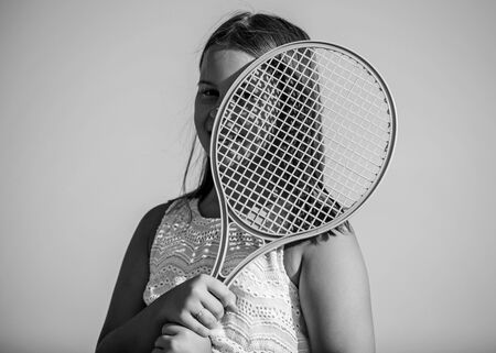 Energy inside. game playing. summer outdoor games. play tennis. childhood happiness. healthy lifestyle. small girl with tennis racquet. summer sport activity. energetic child. happy and cheerfulの写真素材