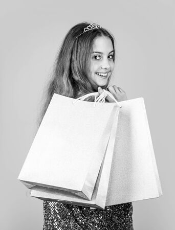 Shopping is always good idea. Happy girl hold shopping bags. Little child enjoy shopping. Small shopper blue background. Shopping and sale. Black Friday. Cyber Monday. Shop now, copy spaceの写真素材