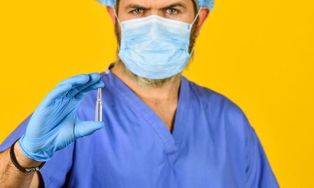 medical specialist hold test tube, selective focus. doctor wear respirator mask. nurse with coronavirus vaccine. pandemic or flu treatment. have immunity. New type pneumonia. Doctors work on symptomsの写真素材