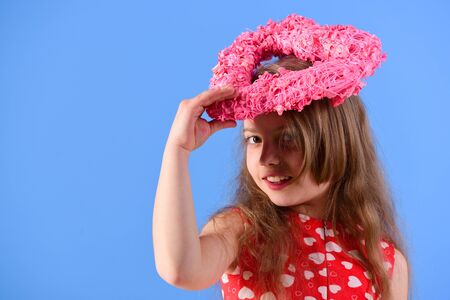 Romantic love concept. Happy girl holding pink heart on head on blue background.の写真素材