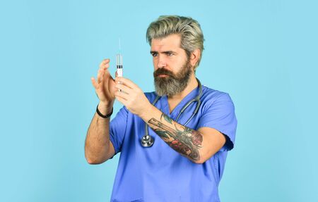 Antidote. Man nurse with coronavirus vaccine in syringe. Flu vaccine. Bearded doctor wear uniform use syringe needle vaccination. Dose injection. Medical injection. Vaccine development. Innovationの写真素材