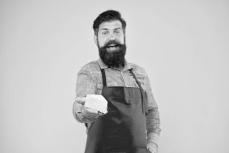 Buy cheese. Gourmet product. Dairy product derived from milk. Online shopping. Diet and nutrition. Cheesemaking concept. Cheese maker. Bearded man in apron hold piece cheese. Shop staff occupationの写真素材