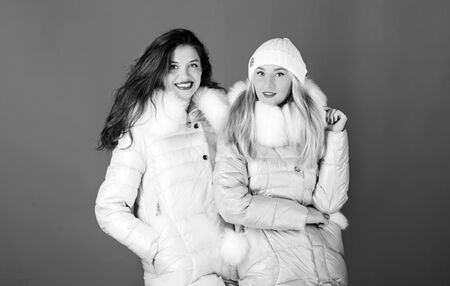 Perfect for frosty winter day. women in padded warm coat. christmas. winter clothing fashion. faux fur down jacket. girls in beanie. flu and cold. seasonal shopping. happy winter holidays. Friendshipの写真素材