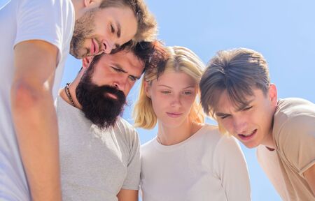Focused on something. Whats there. Group of people with serious look. Friends looking down. Sensual...