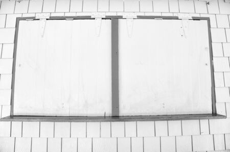 Window with metal shutters on yellow wall in philipsburg, sint maarten. Facade of closed shop, small business. Storefront with security blinds. Architecture, structure and design.の写真素材