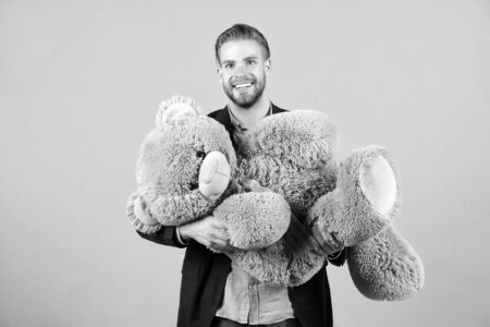Macho smile with grey teddy bear. Happy man big animal toy. Man smile with big animal toy. Gift and present concept. Fashion and style. Birthday or anniversary and holiday celebrationの写真素材