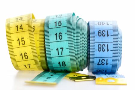 Weight loss and sport concept. Yellow and blue rolled tapes isolated on white background. Three...