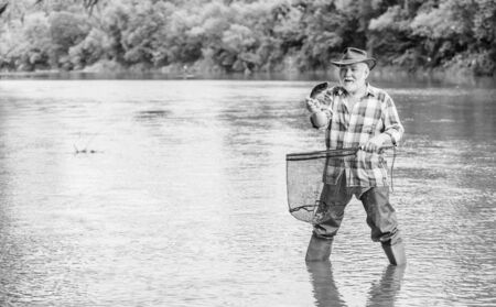 Fisherman fishing equipment. Fisherman alone stand in river water. Pensioner leisure. Man senior bearded fisherman. Hobby sport activity. Fish farming pisciculture raising fish commerciallyの写真素材