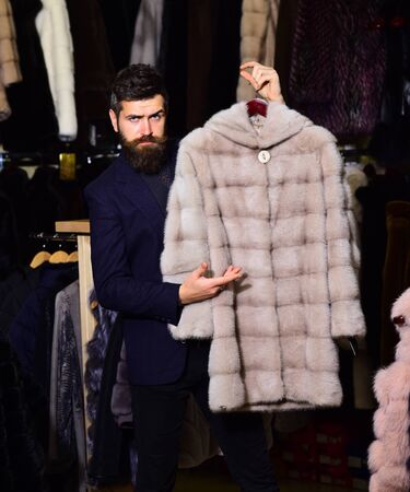 Guy holds furry coat with fur on background.の写真素材