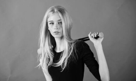 Girl tender blonde hold baseball bat on red background. Woman in baseball sport. Baseball female...
