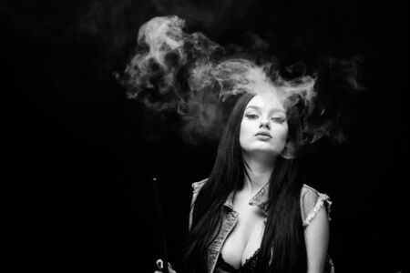 Fashion girl vaping. Relaxing with hookah. Nicotine addiction. Attractive busty brunette smoking...