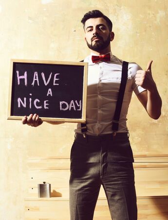 bearded man holding board with inscription with serious faceの写真素材