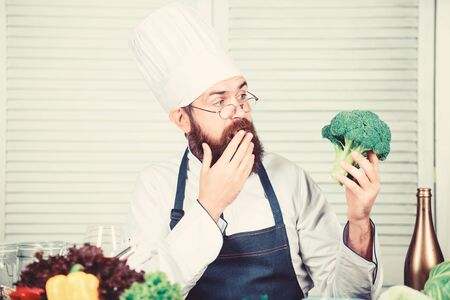 Healthy vegetarian recipe. Organic vegetables. I choose only healthy ingredients. Man cook hat and apron hold broccoli. Healthy nutrition concept. Bearded professional chef cooking healthy food.の写真素材