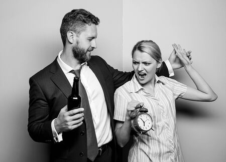 bad relations. family routine. problems in relationship. family psychology. unhappy life. man drink wine. woman show time on alarm clock. wife wondering why husband reveler came home so lateの写真素材