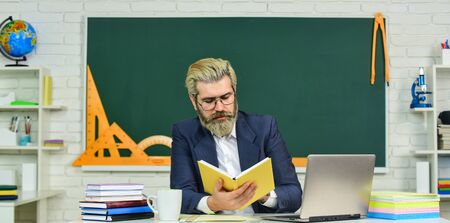 Digital technology. School teacher with laptop. Web development. Teacher teaching programming language. Teacher at classroom. Watch video for step by step tutorial. Handsome man use modern technologyの写真素材