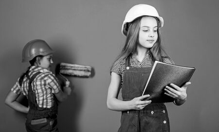 Children sisters run renovation their room. Amateur renovation. Sisters team renovating home. Home improvement activities. Kids girls planning renovation. Repaint walls. Move in new apartmentの写真素材