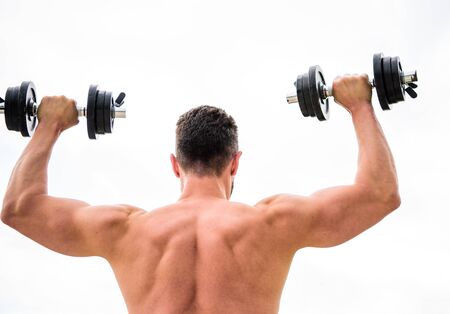 Actions speak louder than coaches. Sportsman with strong back and arms. Sport equipment. Bodybuilding sport. Sport lifestyle. Dumbbell exercise gym. Muscular man exercising with dumbbell rear view.の写真素材