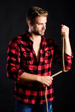 Western life. Masculinity and brutality concept. Adopt cowboy mannerisms as a fashion pose. Man unshaven cowboy black background. Cowboy life came to be highly romanticized. Masculine idealの写真素材