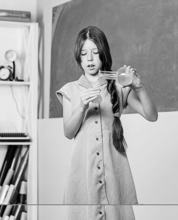 Chemical reaction. Chemical liquid. Science lesson. School laboratory. Scientific experiment. Fascinating lesson. Small girl with chemical tube. Biology education. Girl chemistry class testing tubeの写真素材