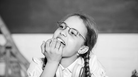 Modern childhood. School break. Schoolgirl sit desk chalkboard background. Kid student in school. Girl small child eating apple fruit. Healthy lifestyle. Snack between lessons. School life conceptの写真素材