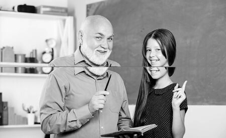 Childhood memories. information. Book store concept. reading school lesson. small girl with man tutor study book. Back to school. Read and write. mature teacher help pupil with literatureの写真素材