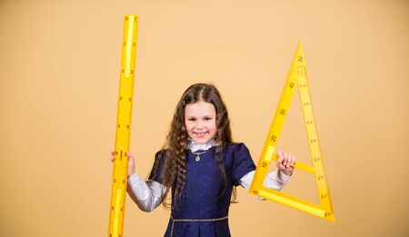 Sizing and measuring. Pupil cute girl with big ruler. School student study geometry. Kid school...