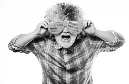 Man senior bearded cheerful person wear colorful wig and sunglasses. Elderly clown. Having fun. Funny lifestyle. Fun and entertainment. Comic grandfather concept. Nice joke. Grandpa always fun.の写真素材