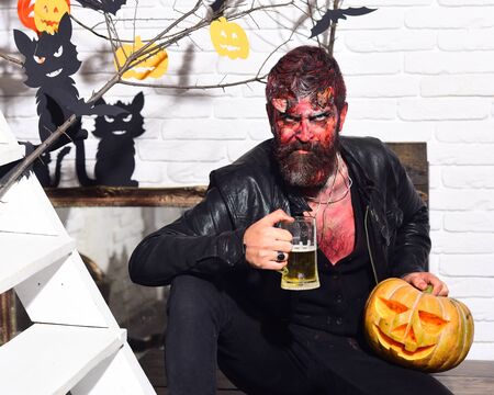 Demon with horns and evil face holds jack o lanternの写真素材