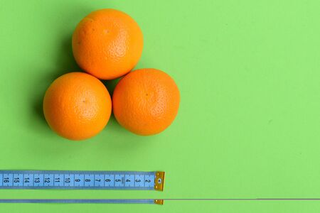 Pattern made of oranges near tape measure in cyan colorの写真素材