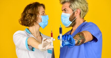 Medical professional working. medical couple use syringe vaccination. say no to coronavirus. virus remedy injection. doctors wear respirator mask. infection vaccine and blood testの写真素材