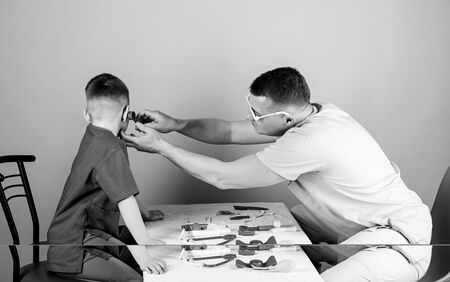 medicine and health. happy child with father with stethoscope. small boy with dad play. Future career. father and son in medical uniform. nurse laboratory assistant. family doctor. doctos assistant.の写真素材