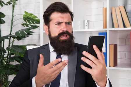 Stress from work. Angry manager hold smartphone in office. Stress management. Stressful work. Business stress. Modern life. Busy lifestyle. Stress in workplaceの写真素材