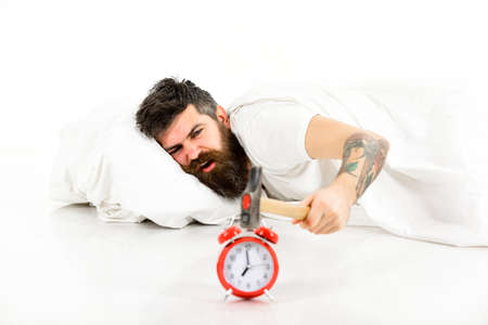Man annoyed by alarm in morning. Young sleepy bearded manの写真素材