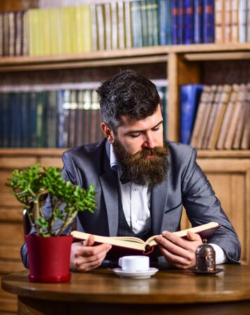 Relax, pleasure, leisure, hobby concept. Bearded man in luxury suit in public library.の写真素材