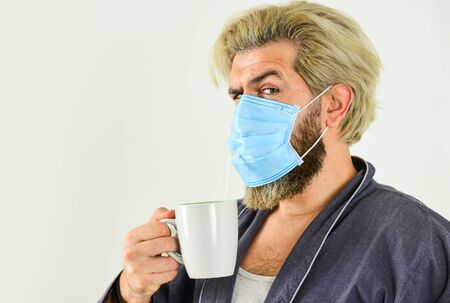 Totally protected. Wearing mask protect from coronavirus. Guy in mask drink tea coffee using straw....